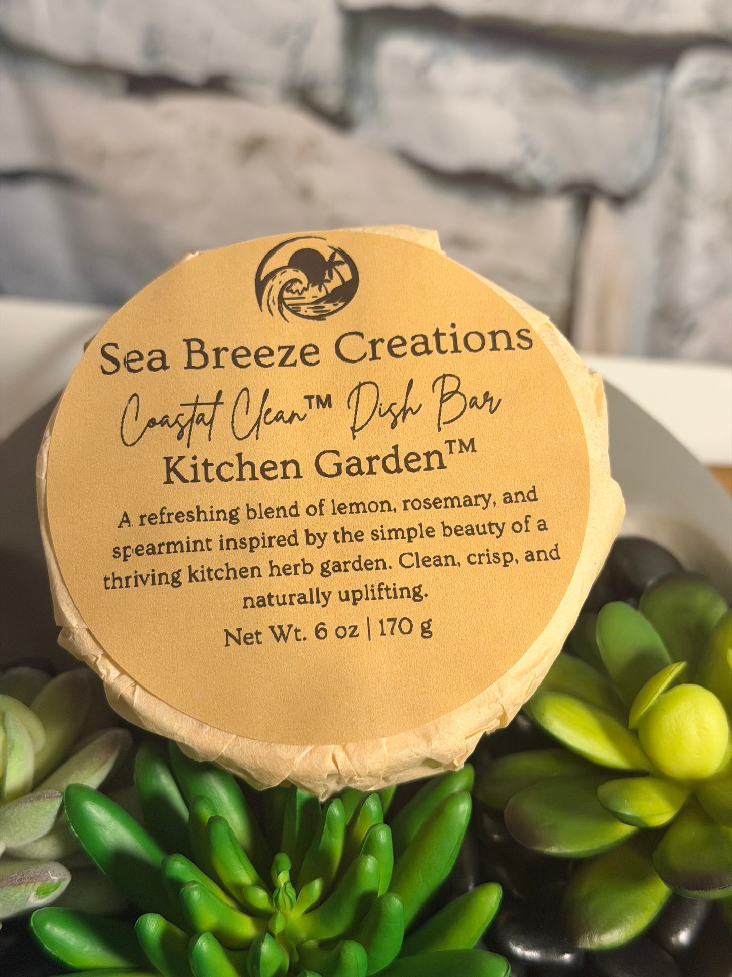Round label on a product with text and branding, surrounded by green plants.