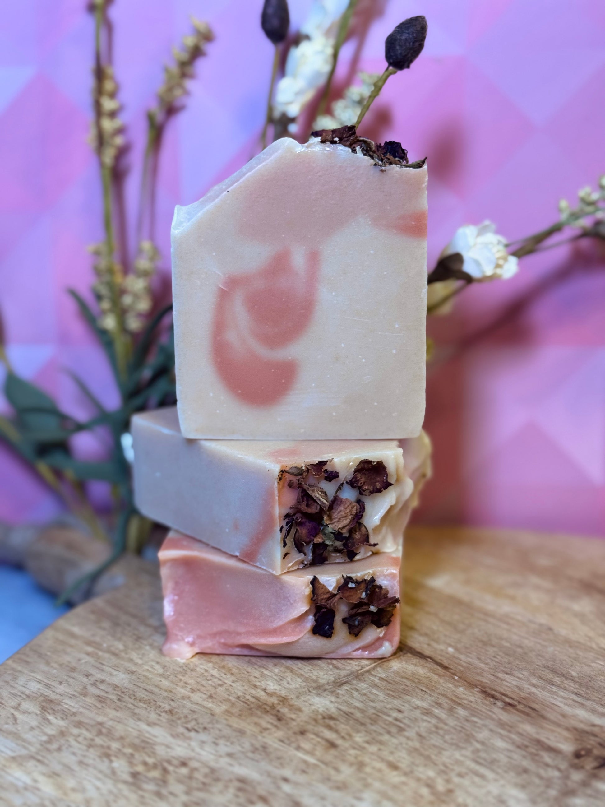 Stack of handmade soap bars with natural ingredients on a wooden surface