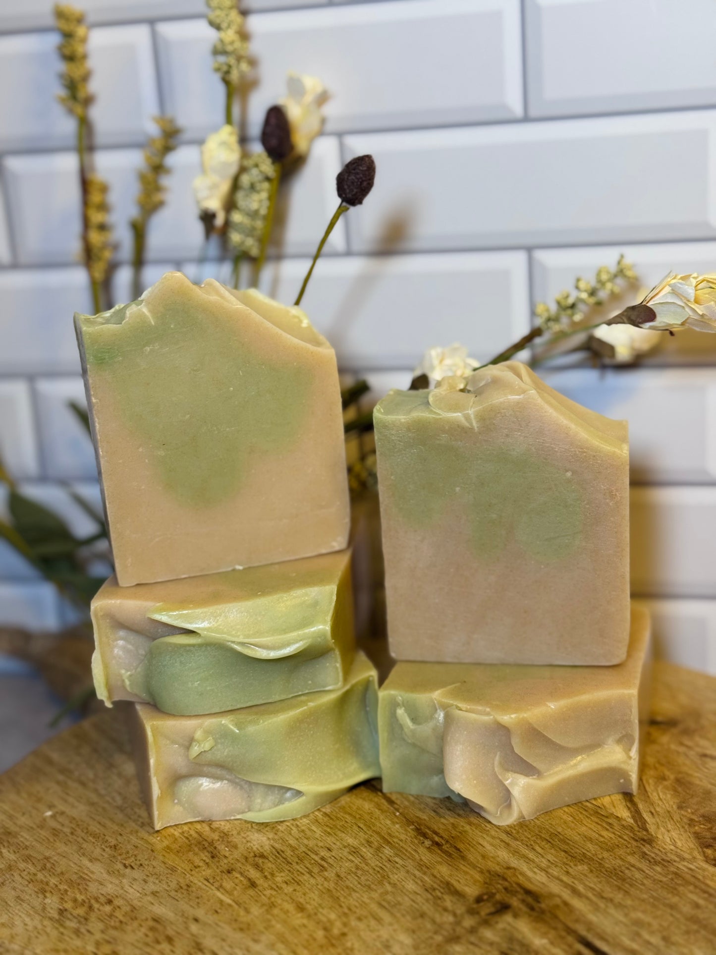 Five bars of green soap on a wooden surface with a white tiled wall in the background. The soap is scented in a fresh scent named Irish Morning Mist. 