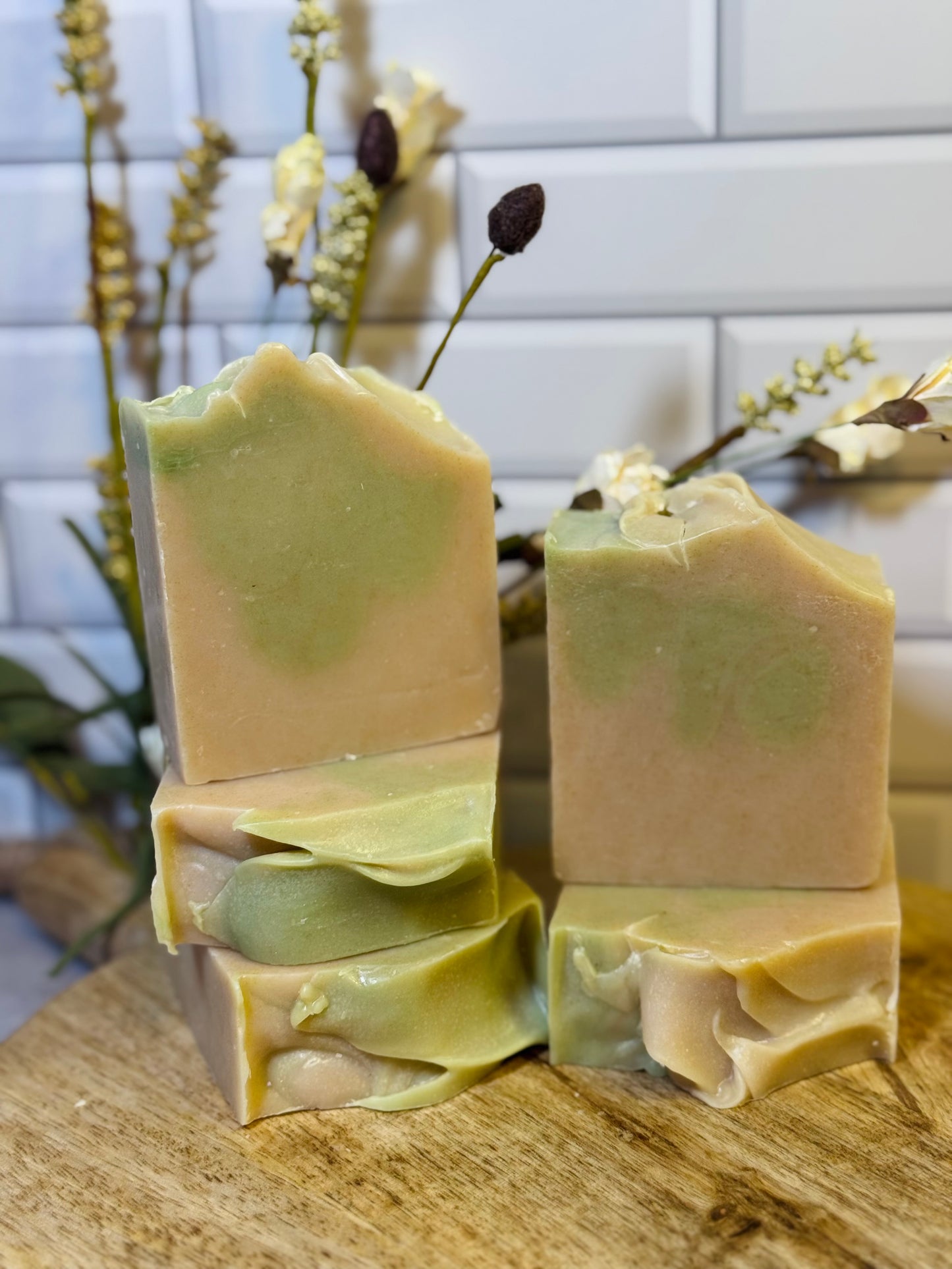Five bars of green soap on a wooden surface with a white tiled wall in the background. The soap is scented in a fresh scent named Irish Morning Mist. 