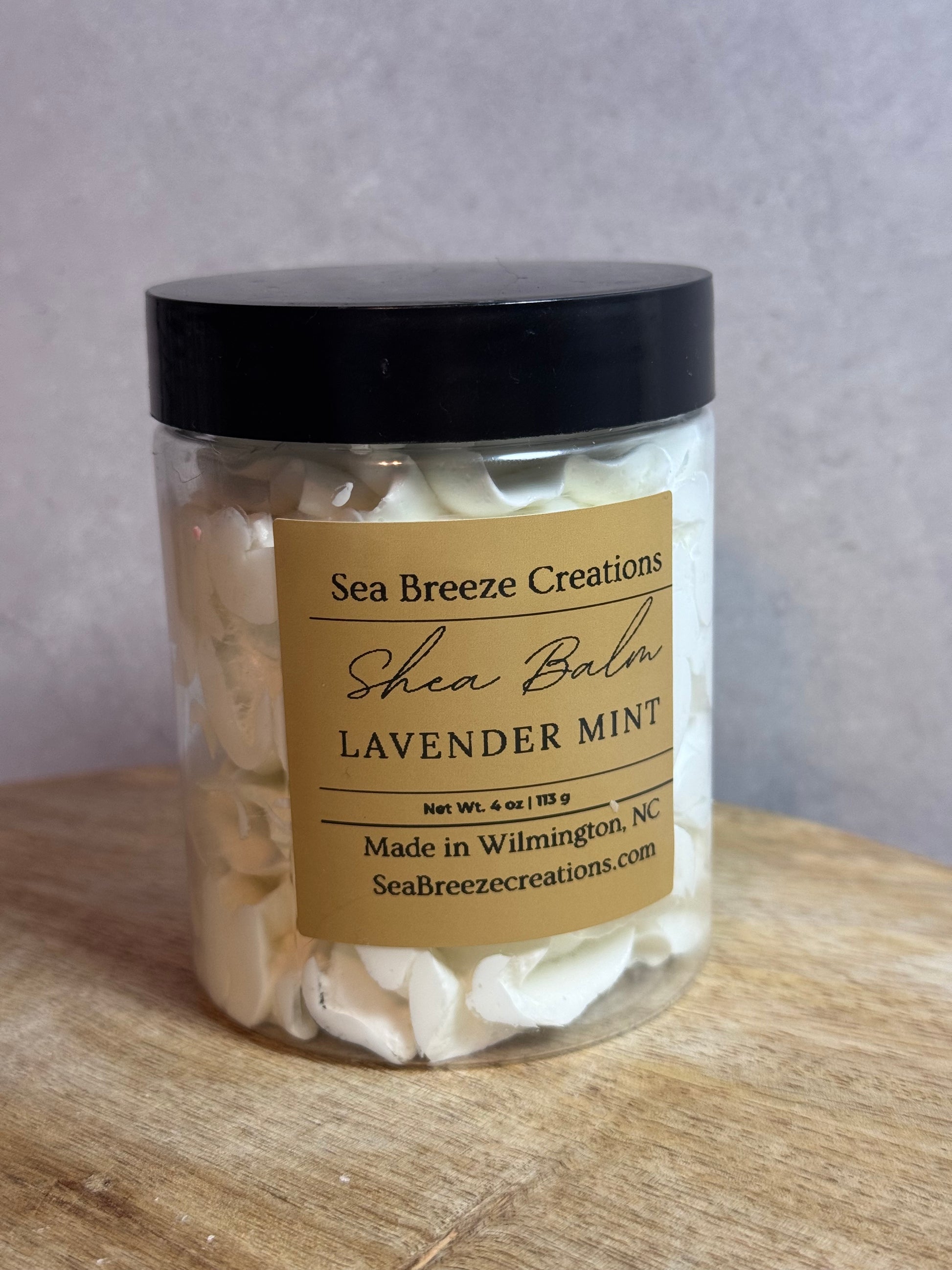 Jar of shea balm with a label on a wooden surface